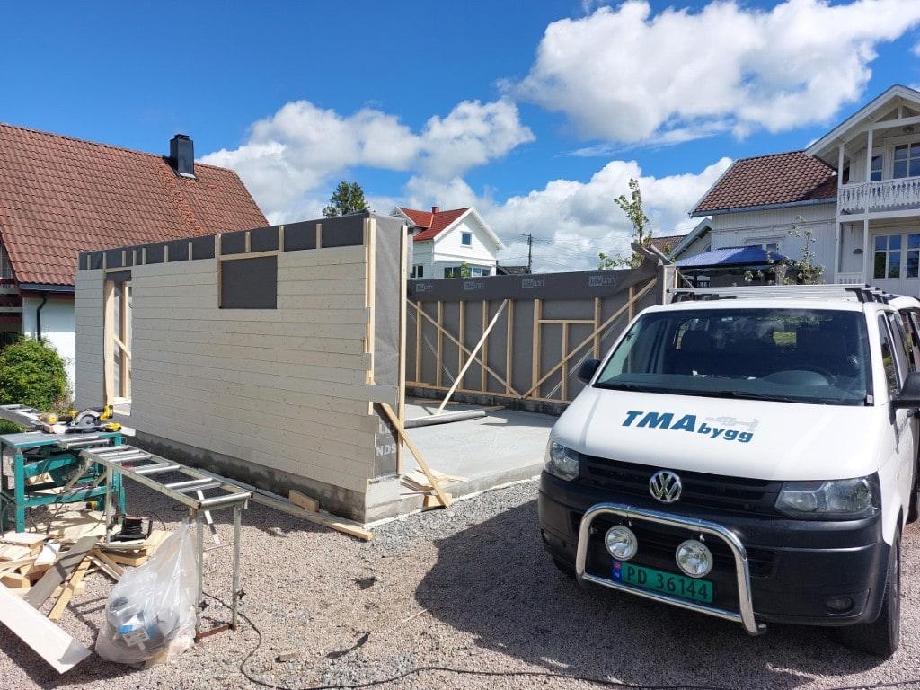 Kledde vegger, med TMA Bygg-bilen parkert foran