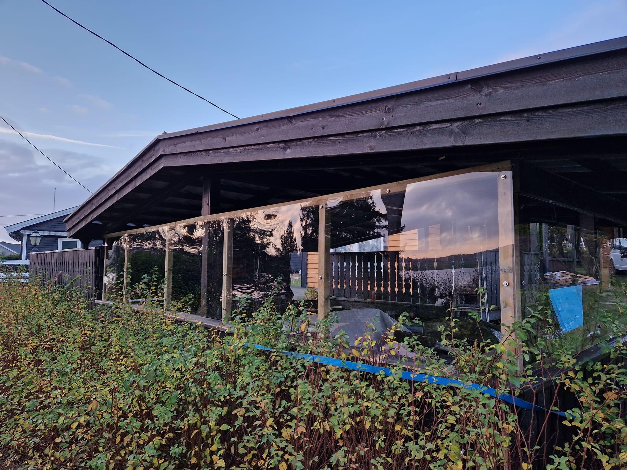 Overbygd uteplass med glassvegger, bygget inntil huset